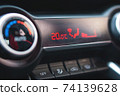 Closeup control buttons and display with temperature placed on dashboard inside contemporary car. 74139628