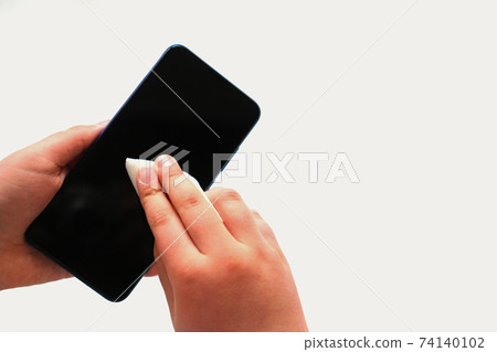 boys hands rubs modern smartphone with a disinfectant wipe. 74140102