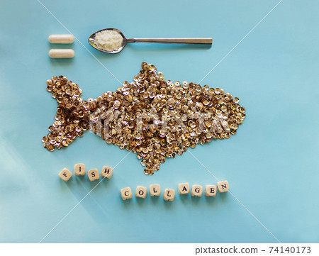 Fish collagen capsules and powder on trendy blue background. Fish collagen capsules and powder on trendy blue background. 74140173