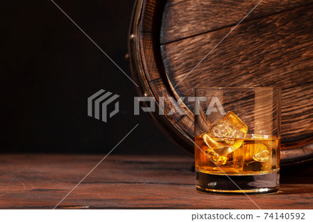 Scotch whiskey glass and old barrel 74140592