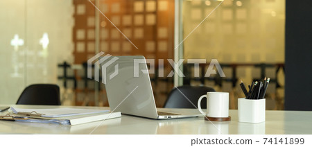 Cropped shot of workspace with laptop, document file, stationery and cup Cropped shot of workspace with laptop, document file, stationery and cup 74141899