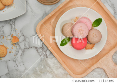 Marble dinning table with a plate of French colourful macarons and biscuit plate Marble dinning table with a plate of French colourful macarons and biscuit plate 74142360