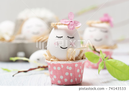 Easter holiday concept with cute handmade white eggs, tree branches, quail feathers and spring flowers on white wooden background. 74143533