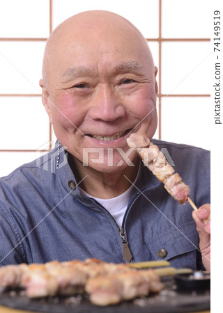 Senior eating yakitori with a smile Senior eating yakitori with a smile 74149519