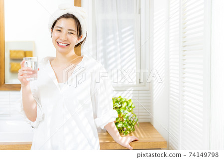 Young woman drinking water in the morning Young woman drinking water in the morning 74149798