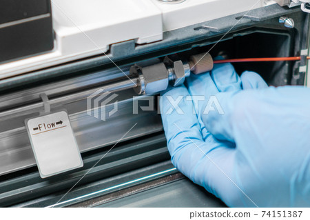 Close up scientist changing a column in HPLC system. Analytical chemistry laboratory. Preparation before analysis. Close up scientist changing a column in HPLC system. Analytical chemistry laboratory. Preparation before analysis. 74151387