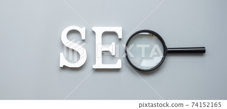 SEO (Search Engine Optimization) text and magnifying glass on gray background. Idea, Vision, Strategy, Analysis, Keyword and Content concept SEO (Search Engine Optimization) text and magnifying glass on gray background. Idea, Vision, Strategy, Analysis, Keyword and Content concept 74152165