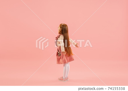 Childhood and dream about big and famous future. Pretty longhair girl isolated on coral pink background Childhood and dream about big and famous future. Pretty longhair girl isolated on coral pink background 74155338