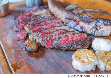 Dry-aged marble beef steak Tomahawk on wooden board with spices. Close-up, dinner concept. Dry-aged marble beef steak Tomahawk on wooden board with spices. Close-up, dinner concept. 74155761