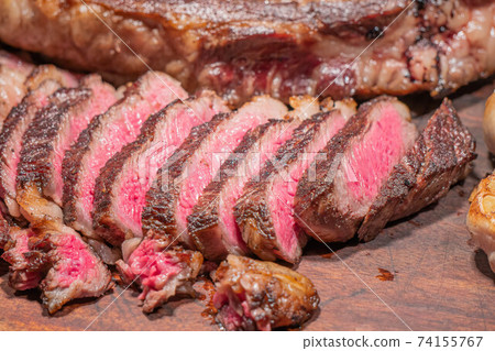 Dry-aged marble beef steak Tomahawk on wooden board with spices. Close-up, dinner concept. Dry-aged marble beef steak Tomahawk on wooden board with spices. Close-up, dinner concept. 74155767