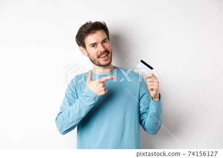 Handsome bearded man recommending bank credit card, standing over white background 74156127