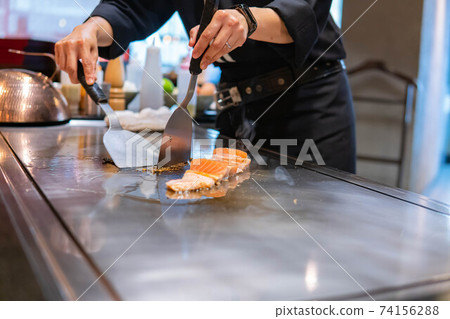 Hand of Chef cooking salmon steak Hand of Chef cooking salmon steak 74156288