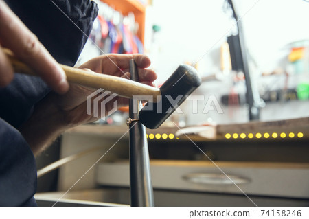 Close up hands of jeweller, goldsmiths making of golden ring with gemstone using professional tools. Close up hands of jeweller, goldsmiths making of golden ring with gemstone using professional tools. 74158246