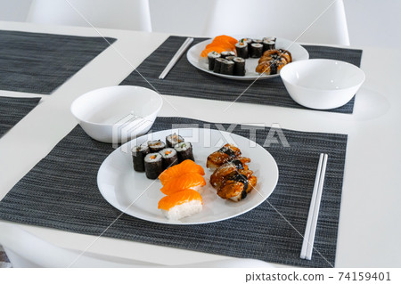 Fresh sushi and rolls in a white plate. Sushi lunch Fresh sushi and rolls in a white plate. Sushi lunch 74159401