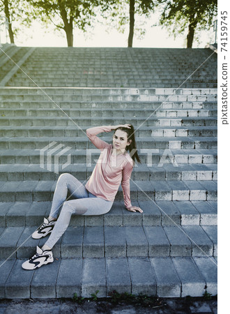 Young woman runner resting after workout session Young woman runner resting after workout session 74159745