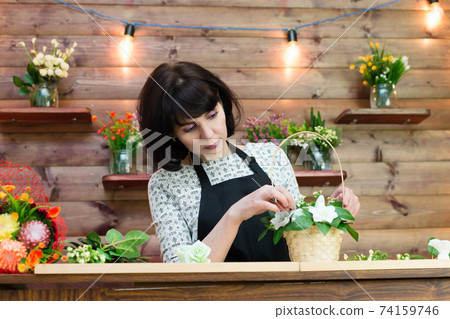 Woman in apron at her workplace in flower shop Woman in apron at her workplace in flower shop 74159746