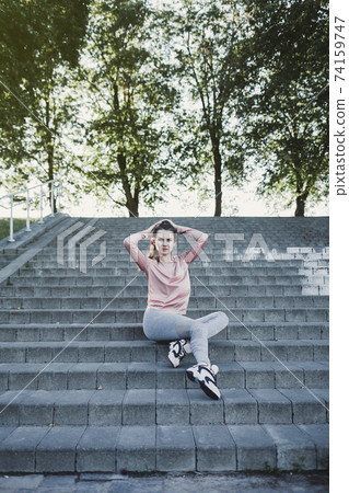 Sports woman resting sitting on stairs Sports woman resting sitting on stairs 74159747