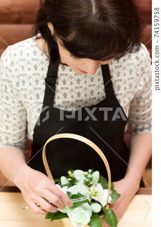 Girl works in a flower shop, top view Girl works in a flower shop, top view 74159758