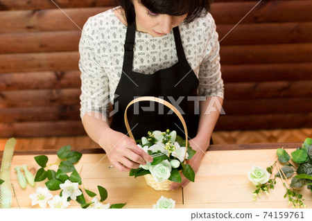 Girl works in a flower shop, top view Girl works in a flower shop, top view 74159761