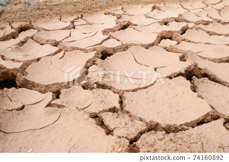 Mudlands that previously contained water have cracked due to hot weather and drought. All water content has been evaporated by the heat 74160892
