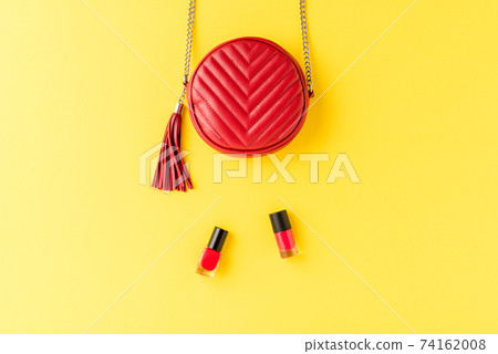 Red leather purse on background with nail polishes. Fashion and beauty background. Flat lay 74162008