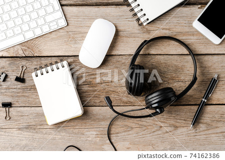 Call center desktop with headset and business accessories. Top view 74162386