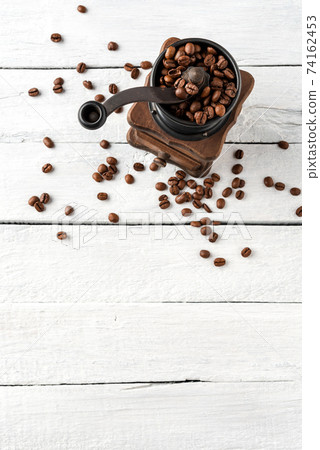 Overhead shot of old coffee grinder on white wooden background Overhead shot of old coffee grinder on white wooden background 74162453