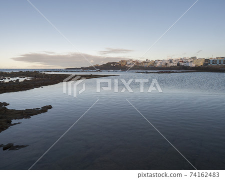 Natural sea swimming pool Charco de San Lorenzo at San Lorenzo Moya with waves of atlantic ocean during sunset, Gran Canaria, Canary Islands, Spain 74162483