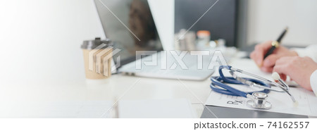 Stethoscope on a table in a physician examination room. Doctor write a prescription or records patient examine results for the patient . Healthcare medicine concept Stethoscope on a table in a physician examination room. Doctor write a prescription or records patient examine results for the patient . Healthcare medicine concept 74162557
