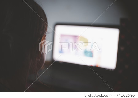 girl child in her bedroom using laptop computer and watching videos after power off light dark room late night girl child in her bedroom using laptop computer and watching videos after power off light dark room late night 74162580