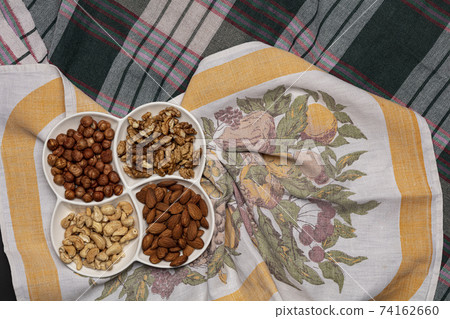 Set of various nuts in white plate 74162660