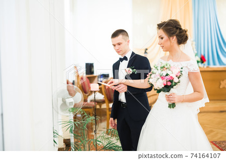 Bride and groom holding candles in church Bride and groom holding candles in church 74164107