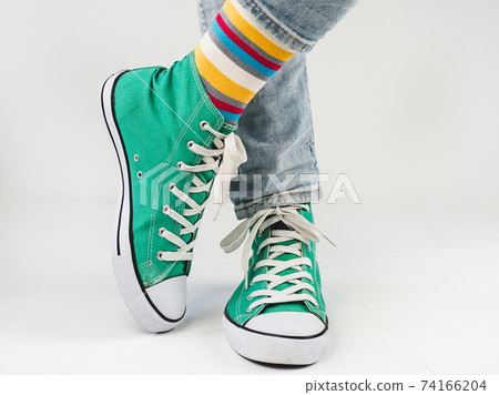 Green sneakers and funny socks on a white background 74166204