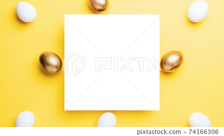 Easter luxury. Golden, white colour egg on pastel yellow background in Happy Easter decoration. Flat lay, top view. 74166306