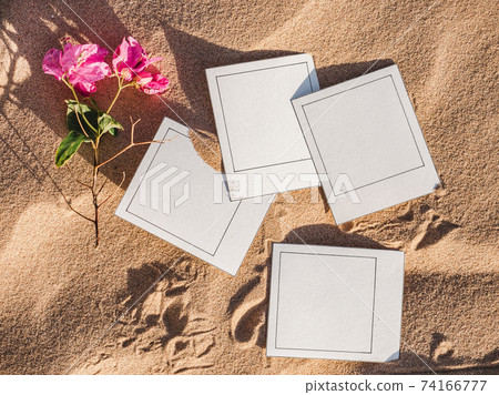 Beautiful photos lying on sand background. Close-up 74166777