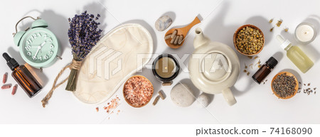 Herbal medicine for treat depression and insomnia concept. Alarm clock, medicine herbs, capsules, camomile tea and aromatherapy oil on white background, flat lay 74168090