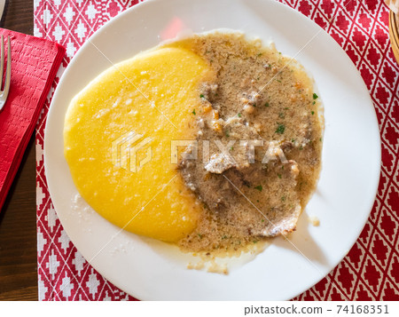 portion of Manzo all'Olio with polenta on plate 74168351