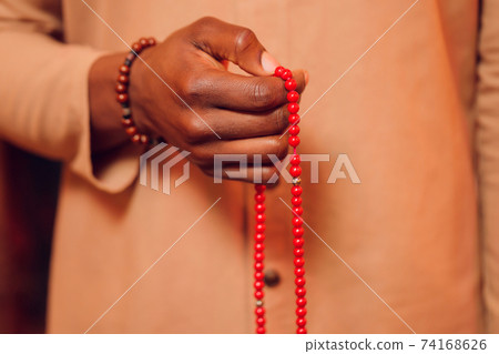 Hand holding a muslim beads rosary or tasbih on a praying mat, pray to god. Ramadhan Kareem. Hand holding a muslim beads rosary or tasbih on a praying mat, pray to god. Ramadhan Kareem. 74168626