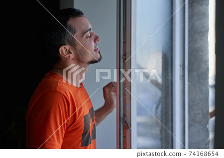 Cold winter weather. man step to window, open it and frosty air rushes from outside through open windows to apartment. Airing housing in cold winter Cold winter weather. man step to window, open it and frosty air rushes from outside through open windows to apartment. Airing housing in cold winter 74168654