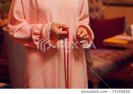 Concentrated woman praying wearing rosary beads. Namaste. Close up hands. Concentrated woman praying wearing rosary beads. Namaste. Close up hands. 74168698