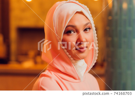 beautiful young woman with a pink hijab. 74168703