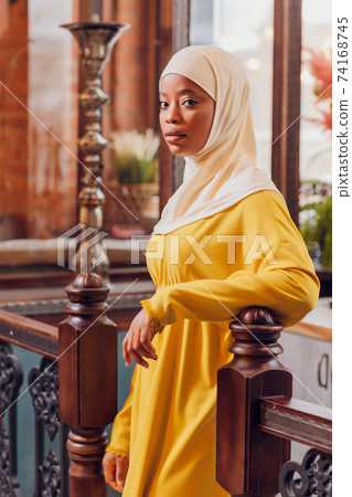 beautiful Muslim girl in hijab smiling, waiting for her food in a restaurant. beautiful Muslim girl in hijab smiling, waiting for her food in a restaurant. 74168745