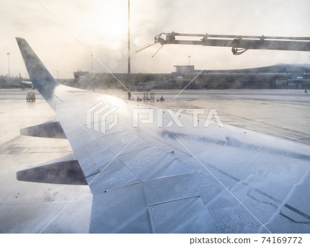 de-icing of aircraft wing by chemicals in airport 74169772