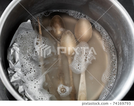 top view of silver teaspoons in boiling solution top view of silver teaspoons in boiling solution 74169793