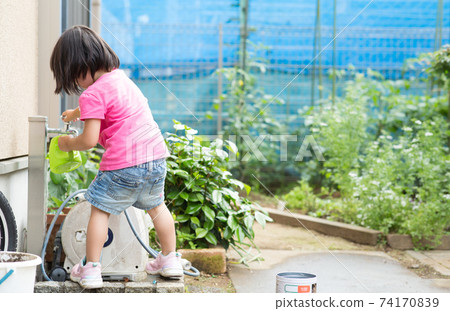Girl enjoying playing in the water 74170839