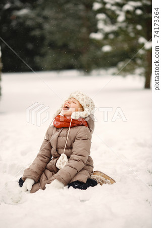 Cute little girl in a winter park Cute little girl in a winter park 74173264
