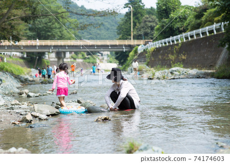Girl playing on the riverbank Girl playing on the riverbank 74174603