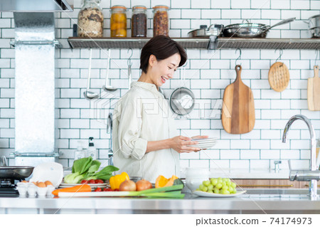 Middle-aged woman in the kitchen 74174973