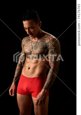 Portrait of athletic young tattooed guy. Studio shot Portrait of athletic young tattooed guy. Studio shot 74176765