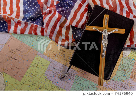 Holy Bible on of the Christian cross the hope of mankind for salvation on way to God through prayer on American flag and U.S. map 74176940